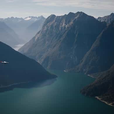 Steep ridges falling to dark green water in a deep fiord